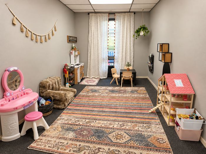 Dramatic play room with a dollhouse and dress-up area